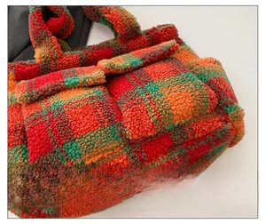 Detail of multi-color checkerboard plush tote bag featuring soft fleece and outer pocket