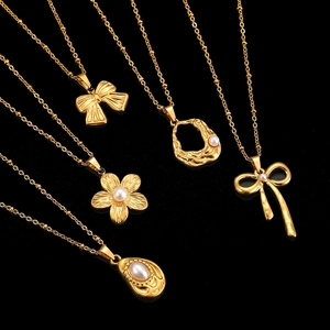 Detailed set of five golden stainless steel necklaces with pearl bow and floral pendants