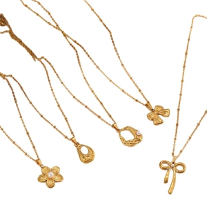 Gold stainless steel pearl necklaces with floral, bow, and organic circle pendants