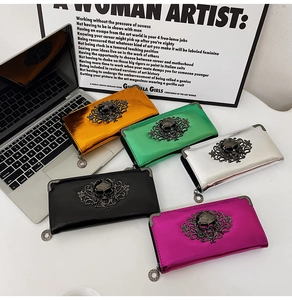 Detailed view of long wallets with 3D skull ornaments in metallic vibrant finishes