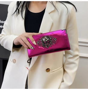 Macro view of metallic magenta wallet featuring silver skull and floral vine hardware