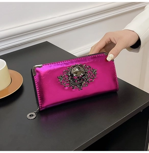 Macro shot of rose pink metallic wallet with gothic skull relief and silver metal corners