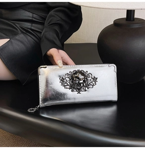 Macro shot of silver long wallet featuring punk skull metal emblem and corner protectors