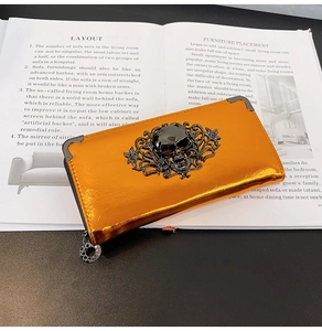 Close-up of orange skull wallet with metallic finish on vintage book background
