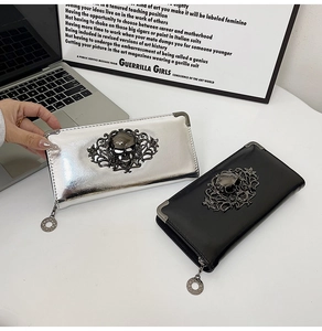 Close-up of metallic punk skull long wallets with decorative metal corners and zip charms