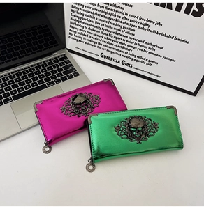 Macro shot of metallic pink and green skull long wallets with vintage metal corners