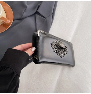 Detailed view of the silver metal skull and floral carving on the black long wallet