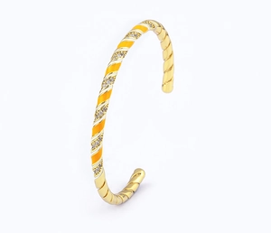 Close-up of 18k gold-plated spiral bangle with yellow enamel and white zircon inlay