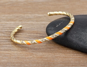 Detailed view of 18k gold plated cuff with colorful enamel patterns and zircon accents