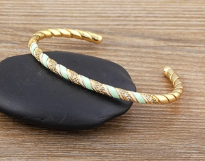 Detail of bohemian gold-plated cuff featuring green enamel check pattern and pavé zircons