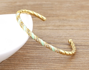 Detail of 18k gold plated bangle with mint green enamel and sparkling white zircons