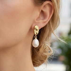 Close-up of elegant 18K gold plated hammered earring with a drop freshwater pearl