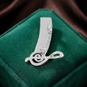 Detailed back view of silver piano note brooch showing secure safety pin clasp