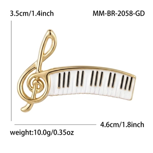 Elegant gold piano and treble clef brooch with white enamel detail, size 4.6cm x 3.5cm