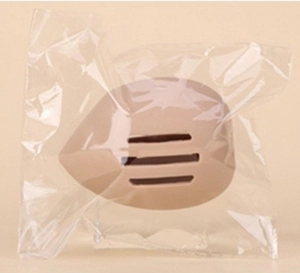 Close-up of nude breathable bra pads with ventilation grooves in clear plastic packaging