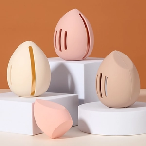 Portable silicone makeup sponge holders in pink and beige on white geometric stands
