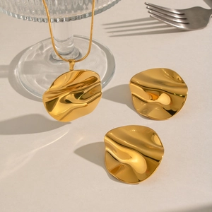 Golden irregular round necklace and earrings set with organic wavy metal texture