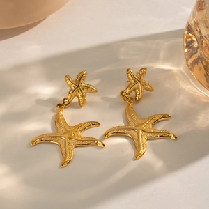 Macro shot of gold stainless steel starfish drop earrings with realistic textures