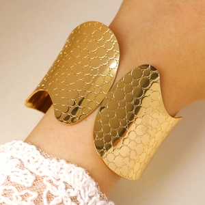 Detail of gold chunky cuff bracelet featuring unique bubble texture and open design