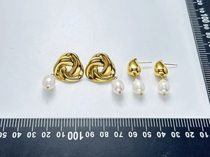 Mesure détaillée des boucles d'oreilles fleurs en or avec perles d'eau douce sur une règle