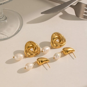 Détail de boucles d'oreilles nœud doré et clous goutte avec perles d'eau douce
