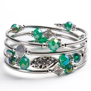 Detail view of multilayer wrap bracelet with green faceted beads and floral metal charms