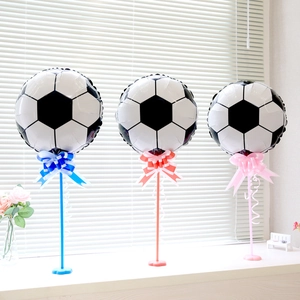 Three soccer foil balloons on stands with colorful ribbons for sports party decorations