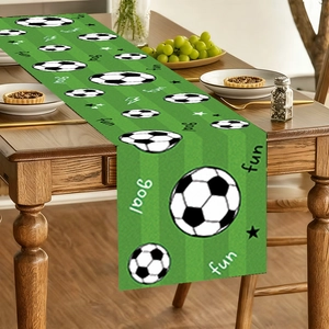 Close-up of a green football field themed table runner with soccer ball patterns and goal text