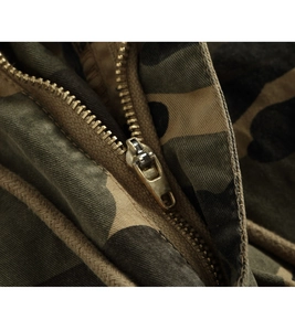 Close-up of durable metal zipper on camouflage cargo pants showing twill fabric texture