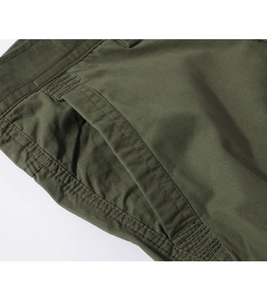 Detailed close-up of army green cargo pants showing reinforced stitching and twill fabric
