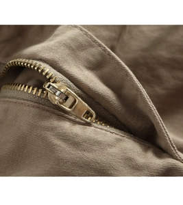 Detailed macro view of vintage metal zipper on brown twill cotton cargo pants
