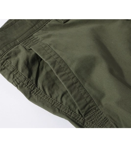 Macro detail of military green cargo pants featuring reinforced side pockets and stitching