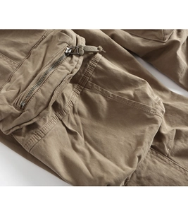 Detailed close-up of khaki cargo pants pocket with metal zipper and reinforced stitching