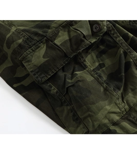 Detailed view of camouflage cargo pants featuring large flap pocket and reinforced seams
