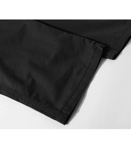 Detailed close-up showing reinforced double stitching on black cargo pants fabric