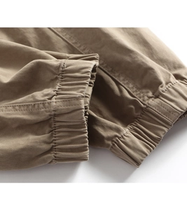 Detailed close-up of khaki cargo pants with elastic cuffs and twill cotton texture