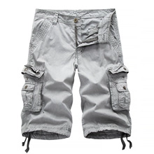 Detail of light grey cargo shorts showing large side pockets with flap buttons and hem drawstrings