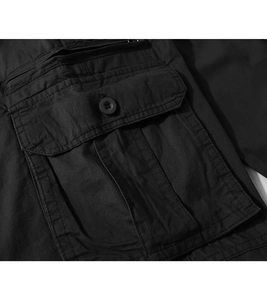 Detail of cargo pants flap pocket with matte black button and twill fabric texture