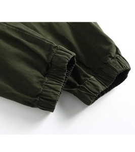 Close-up of dark green cargo pants featuring elastic ribbed cuffs and durable twill fabric