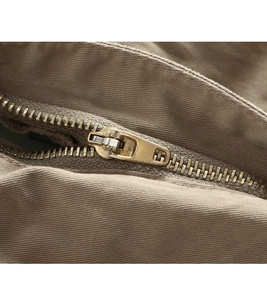Macro detail of high-quality metal zipper and khaki twill fabric on cargo pants