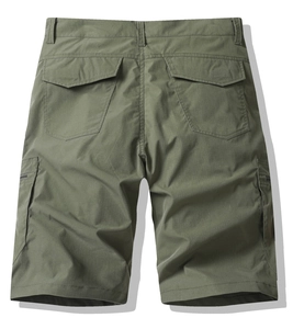 Detailed view of army green cargo shorts featuring flap back pockets and woven fabric texture