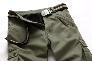 Detailansicht der grünen Cargohose mit Twill-Stoff und Gürtel mit Adler-Prägung auf Metallschnalle