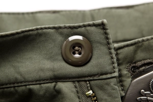 Detail der armygrünen Cargohose mit robustem Knopfverschluss und verstärkten Nähten