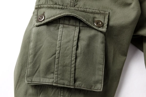 Detail der armygrünen Cargohose mit großer Seitentasche und Doppelknopf-Klappenverschluss