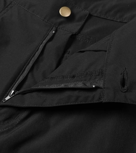 Detail of cargo shorts featuring durable black fabric with a vintage gold metal button