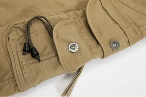 Detail of khaki cargo pants with silver JEANS button and olive green drawstring