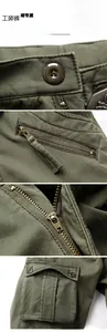 Dettaglio dei pantaloni cargo invernali verde militare con cerniere e tessuto resistente