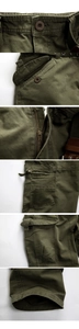 Detailed views of army green cargo pants featuring reinforced pockets and metal zippers