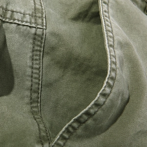 Men's olive green cargo pants with premium cotton twill texture and detailed stitching