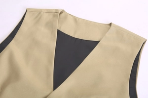 Close-up of khaki V-neck vest showing twill fabric texture and black inner lining